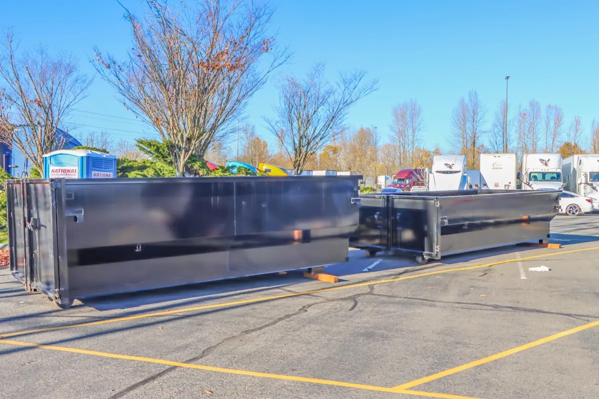 Professional dumpster rental service with roll-off container on residential driveway in Fair Haven